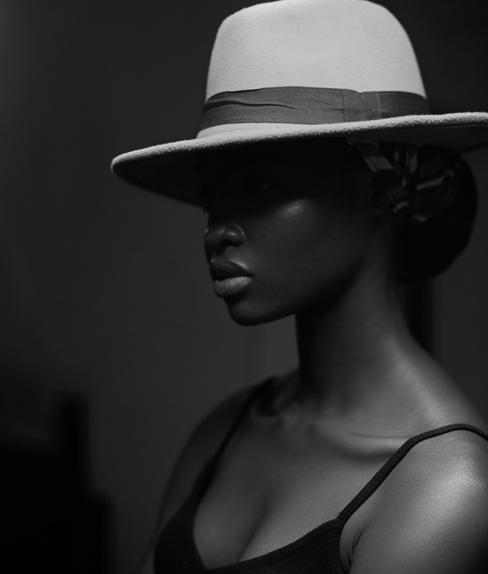 image of black woman with face hidden in shadow under a hat